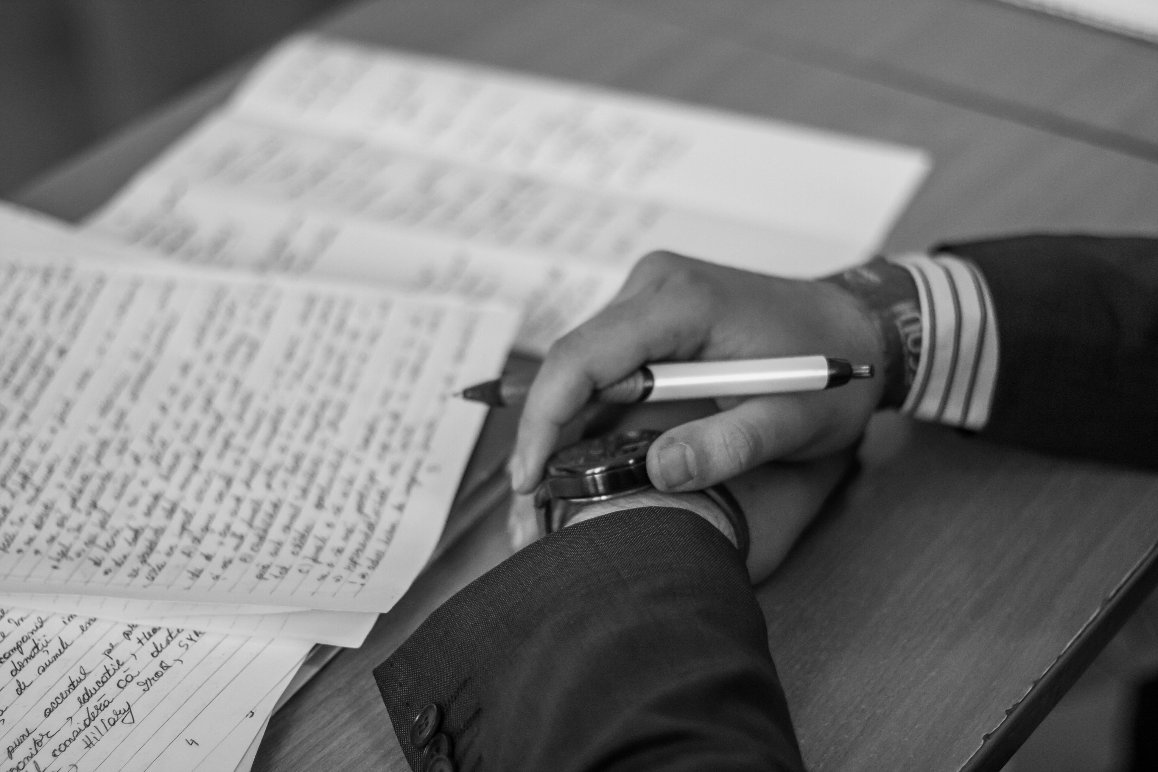 grayscale-photography-of-person-holding-pen-783737